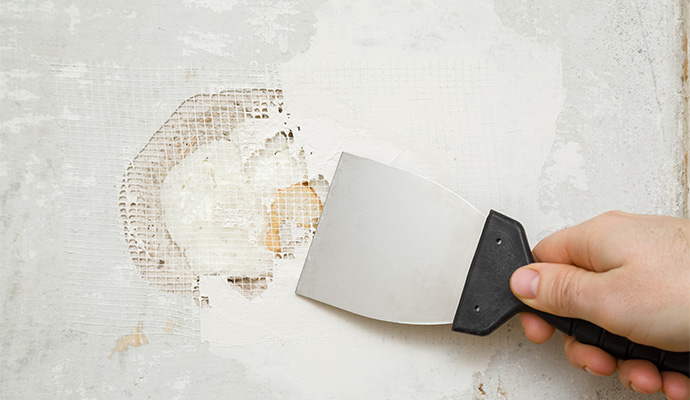 A person patching a damaged wall