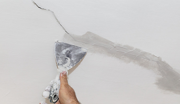 A professional patching a cracked wall